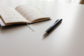 テーブルの上の手帳とボールペン