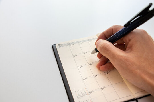 手帳のカレンダーに予定を書き込む