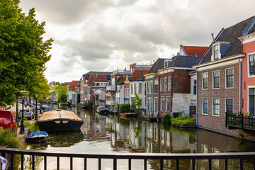 Fototapeta na wymiar Cityscape of Leiden during cloudy day, South Holland, Netherlands. Embankment of city canal.