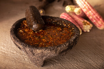 Molcajete with chile de arbol sauce. Traditional mexican version of mortar and pestle handmade of...