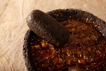 Molcajete with chile de arbol sauce. Traditional mexican version of mortar and pestle handmade of volcanic stone. Essential element in the preparation of the authentic Mexican sauce