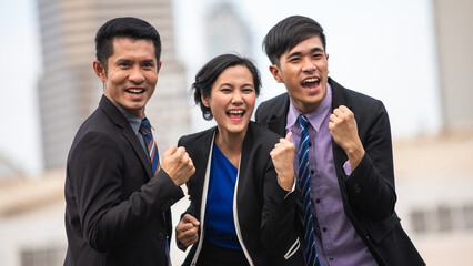 Asian business men and women express joy and happiness in the successful work outside office