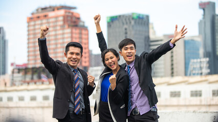 Asian business men and women express joy and happiness in the successful work outside office