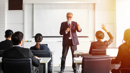  businessman and business women raises his hand to ask a question to the meeting.