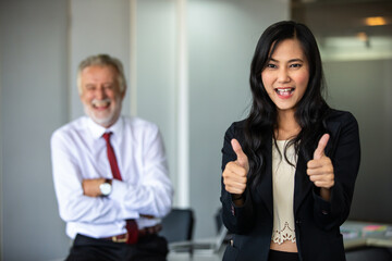 Businesswoman thumbs up and stands smiling confidently and laughing happy in the conference room.