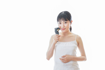 髭剃りを使う若い女性