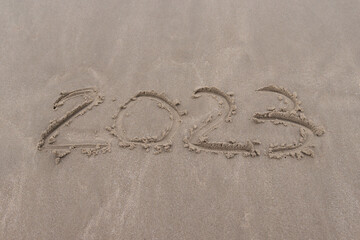 text 2023 on the sand of beach symbol new year 2023