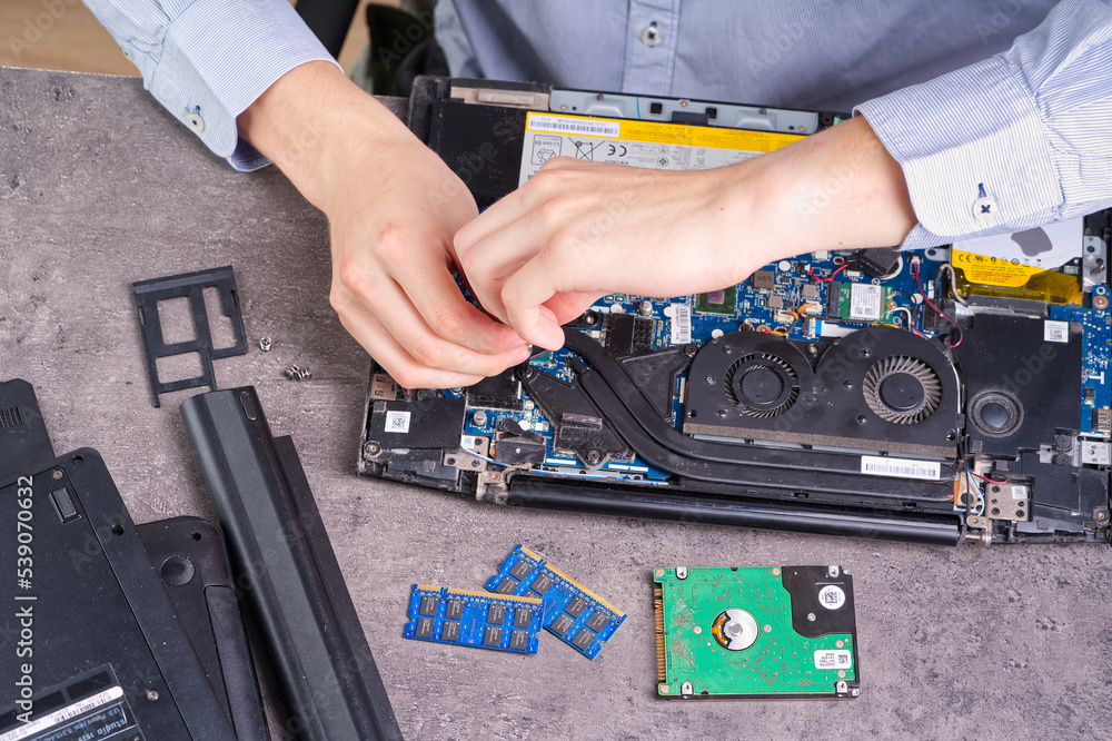 Aufkleber notebook repair. man disassembles a laptop. removes the keyboard. computer service and repair concep