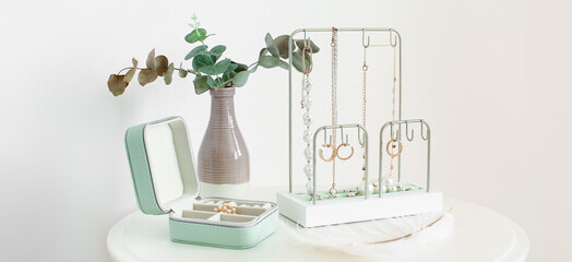 Organizers for jewellery on table near light wall