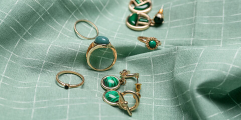 Stylish woman's jewelry on green fabric