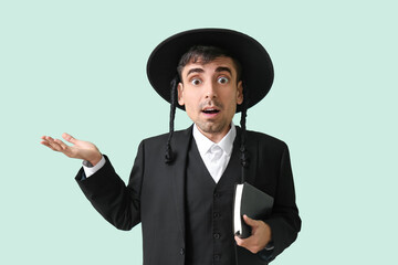 Surprised hasidic Jewish man with bid head on light color background