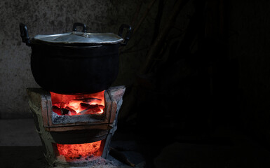 Cooking in a rustic, retro style by using a charcoal stove Anglo with a stainless steel pot. Black with soot Through the use of a long time. Charcoal stove lights up red light, heat has a boiler.