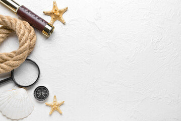 Fototapeta na wymiar Vintage spyglass, magnifier, rope, compass and starfishes on light background
