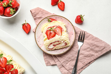 Plate with slices of tasty strawberry roll cake on light background