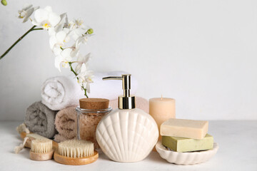 Set of bath supplies with orchid flower on light background