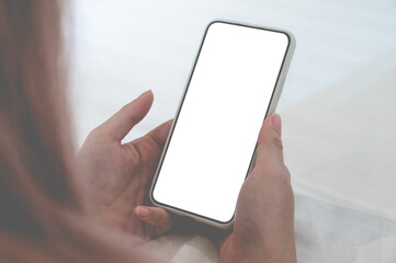 Close up relax women using a smartphone with an empty white screen lazy on the bed at home.