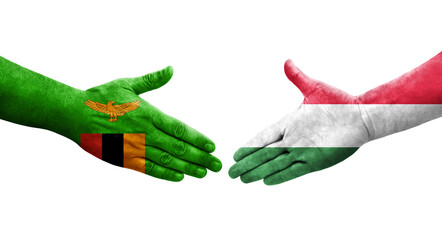 Handshake between Hungary and Zambia flags painted on hands, isolated transparent image.