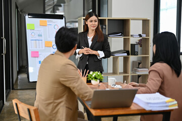 Professional Asian businesswoman or manager training her staff in the company meeting.