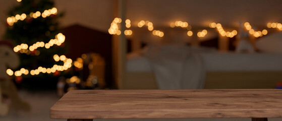 Copy space on wooden tabletop over blurred bedroom with Christmas tree at night