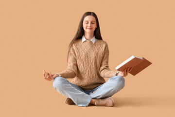 Beautiful woman with book meditating on beige background - obrazy, fototapety, plakaty