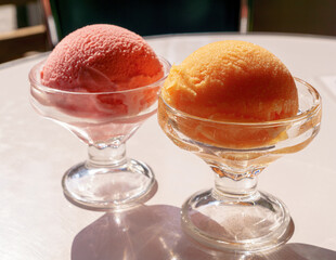 Ice ball  in cocktail glass tangerine and cherry