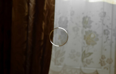 Perfectly round transparent soap bubble on a brown and white background