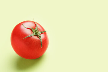 Fresh ripe tomato on green background