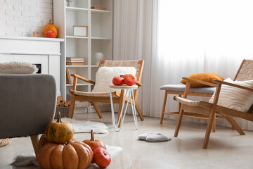 Interior of cozy living room with pumpkins and armchairs