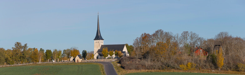 Old 1100s white stone church Sånga Säby Kyrka in the district Svartsjö a sunny autumn day in Stockholm