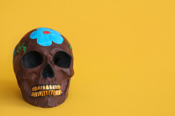 Painted skull for Mexico's Day of the Dead (El Dia de Muertos) on orange background