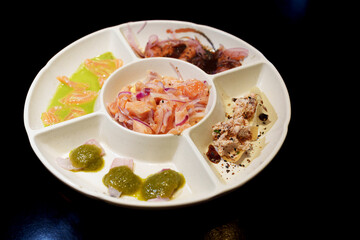 Diversos sushimis de salmão e outros tipos de peixes colocados separadamente dentro do prato e servidos sobre a mesa. Culinária japosesa. 