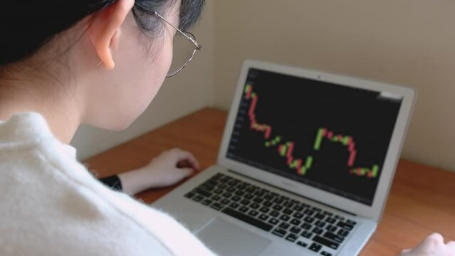Person looking at candlestick chart of Bitcoin on a laptop - closeup  