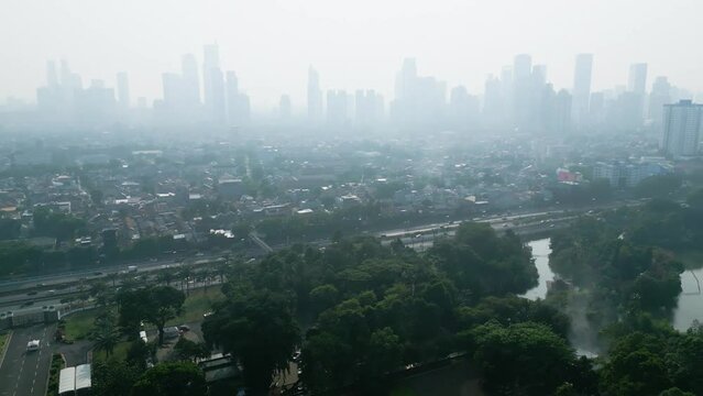 Traffic road with urban buildings at misty morning