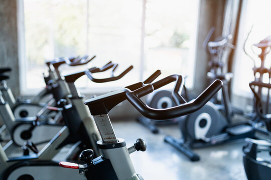 Fitness center club with training exercise bikes. Modern gym interior with equipment. Workout with sport bike equipment for training or burn callories the for sport exercise concept.