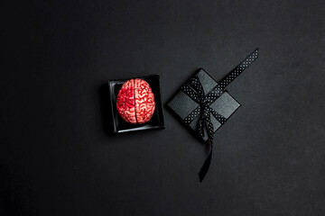 Creepy human brain in a gift box on a black background.
