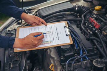 Close up Car Mechanic man hands repairing car auto repair shop. Man hands fixing machinery vehicle...