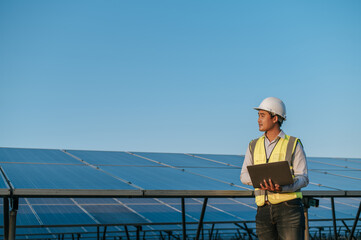 Young Asian technician man checking operation photovoltaic solar panel