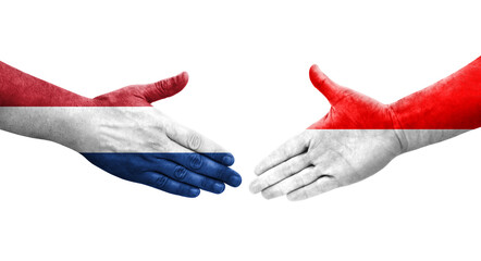 Handshake between Indonesia and Netherlands flags painted on hands, isolated transparent image. - obrazy, fototapety, plakaty