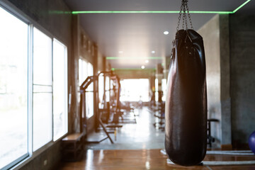 Punch bag at fitness center club with training exercise boxing sandbag. Modern gym interior with...