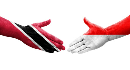 Handshake between Indonesia and Trinidad Tobago flags painted on hands, isolated transparent image.