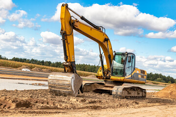 Powerful excavator at a construction site against a blue cloudy sky. Earthmoving equipment for construction. Development and movement of soil.