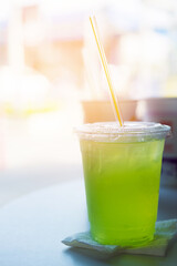 Lemonade apple in a plastic glass. Summer cocktail with green apple and ice