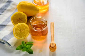Honey with fresh lemon on wooden table background,  honey dipper