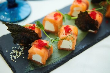 Cheese and red fish rolls on a plate. Several types of Japanese food from fish, vegetables and algae