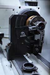 Production of bearings. A machine for processing parts for bearings. Photos without people in a real factory.Selective focus.Vertical photo.