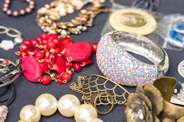 Retro style bracelets and necklaces. Vintage old-fashioned jewelry at flea market stall or car boot sale. Vintage goods for sale. Garage sale concept. Selective focus - obrazy, fototapety, plakaty