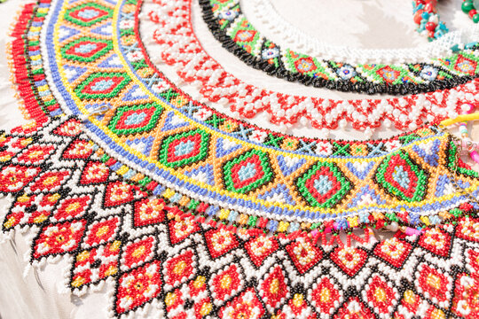 Colorful beaded necklaces - traditional Ukrainian ethnic style jewelry in vibrant colours, hutsul jewellery. Handmade necklaces at souvenir stall or street market. Hutsul kryza. Selective focus