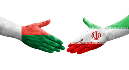 Handshake between Iran and Madagascar flags painted on hands, isolated transparent image.