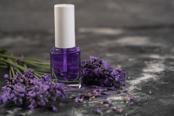 Bottle of essential oil and lavender flowers on wooden table. Lavandula oleum for cuticle
