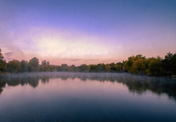 Fototapeta premium Early morning mist over a lake in Needham Market, Suffolk, UK